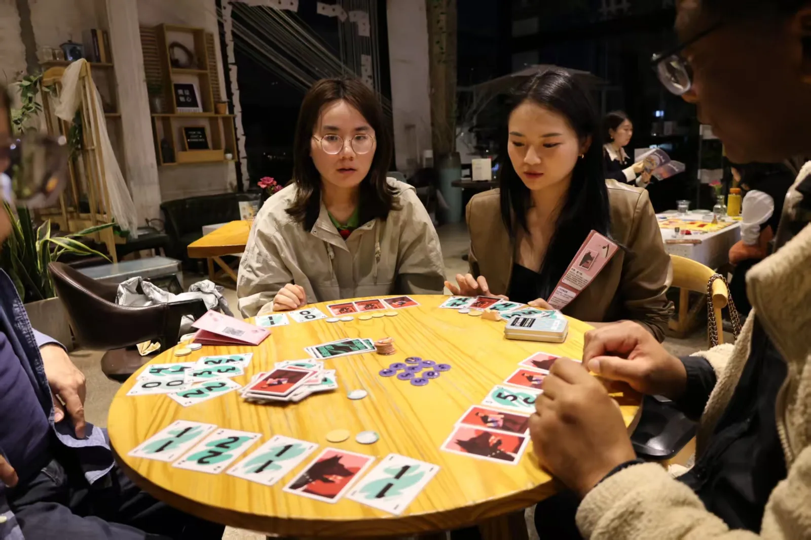A card game in progress on a round wooden table