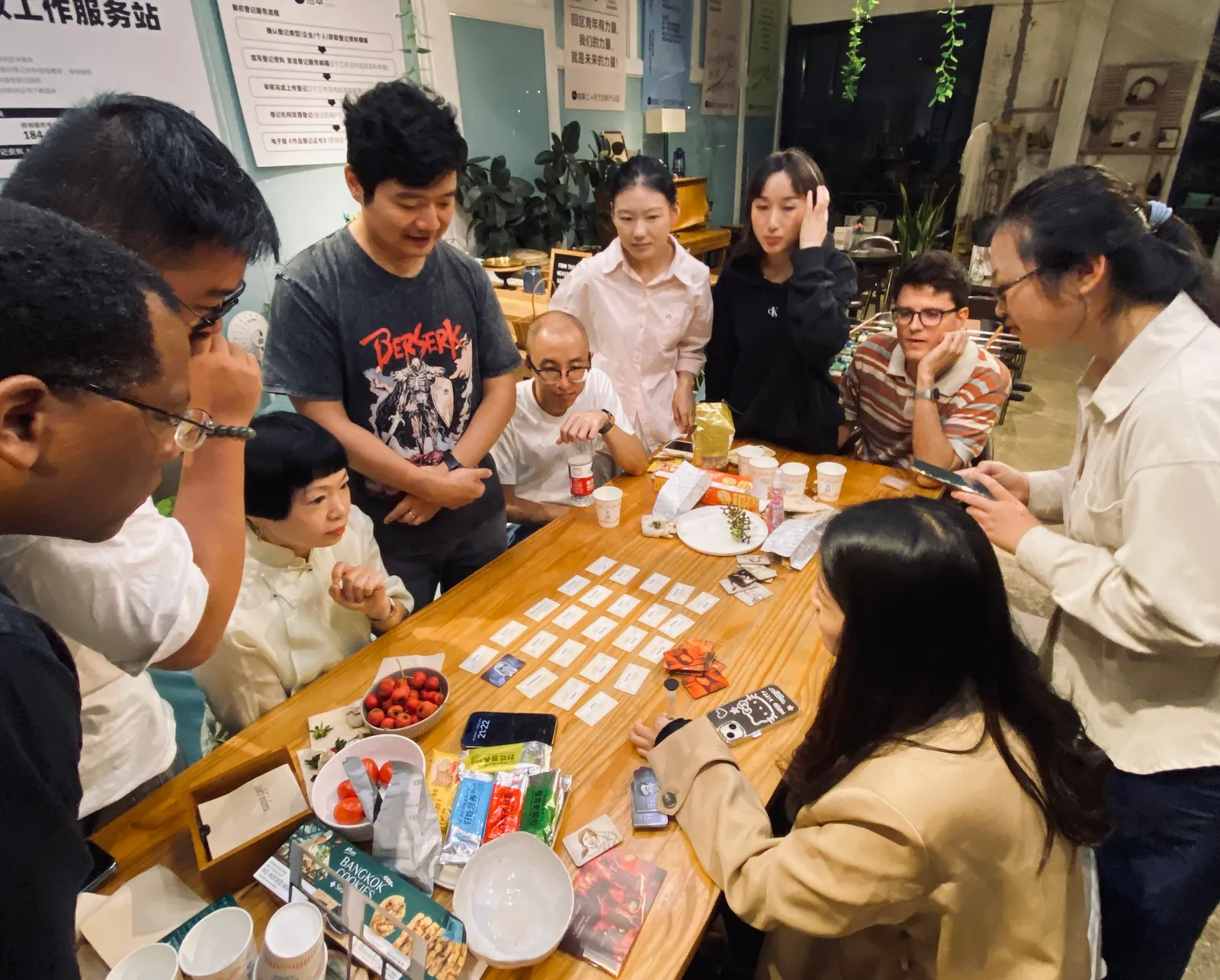 A dozen people crowded around a grid of word cards on the big table