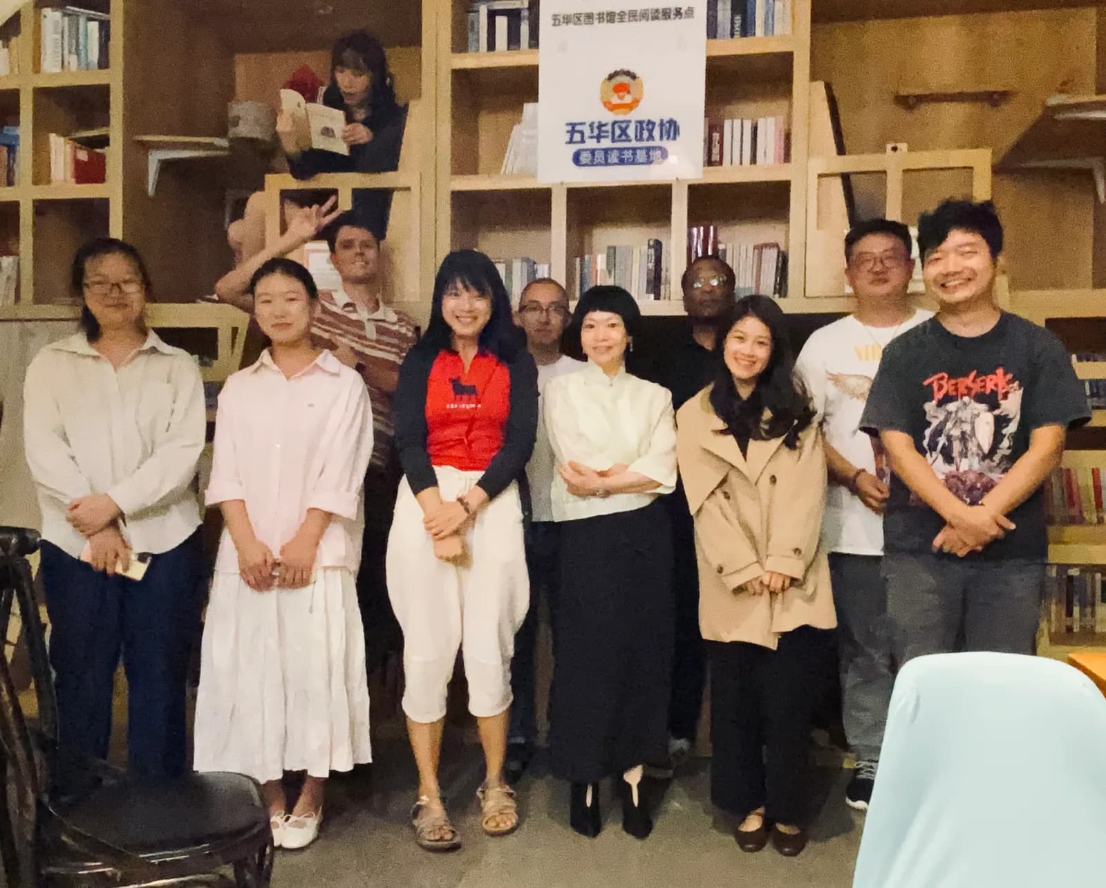 Board game night regulars lined up for a group photo in front of the cafe bookshelves